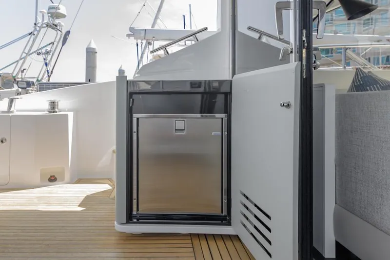 Slide: The Image of Azimut 60 Flybridge 2021 yacht deck with stainless steel fridge and wooden flooring. - 19