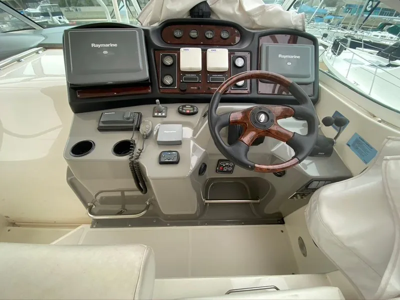 Slide: The Image of 2005 Cruisers Yachts 405 Express Motoryacht helm with Raymarine electronics and wood-accented steering wheel. - 13