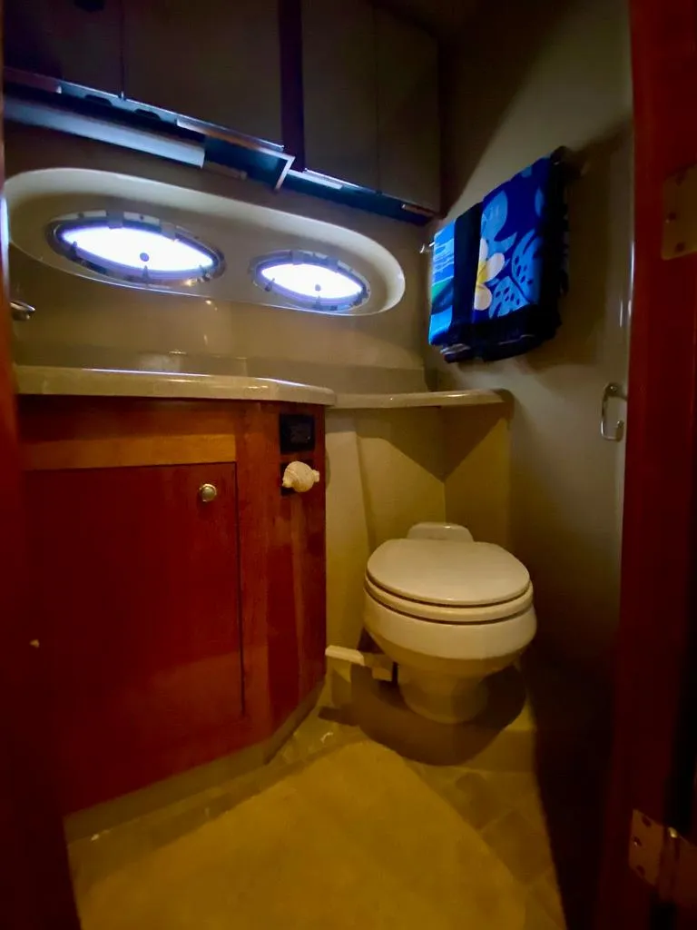 Slide: The Image of 2005 Cruisers Yachts 405 Express Motoryacht bathroom with portholes and wooden cabinetry. - 31