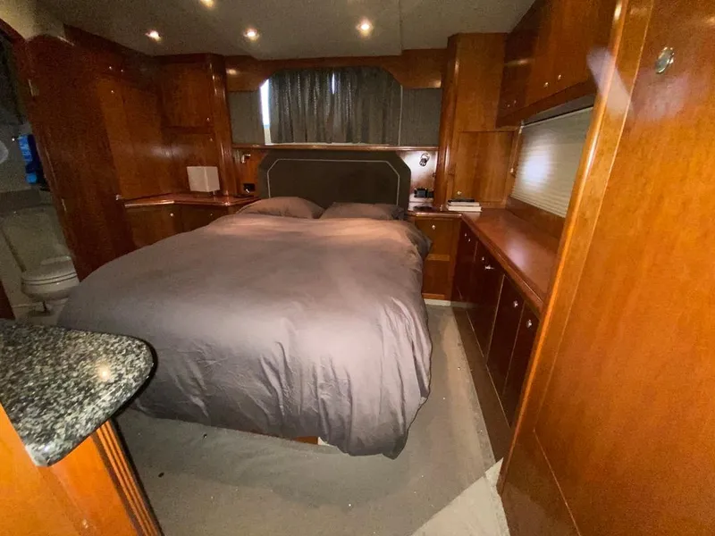 Slide: The Image of Luxurious bedroom in 2005 Cruisers Yachts 405 Express Motoryacht with wood cabinetry and cozy bedding. - 34