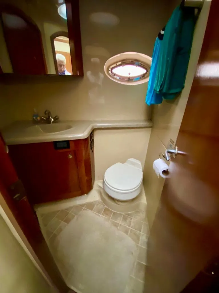 Slide: The Image of 2005 Cruisers Yachts 405 Express Motoryacht bathroom with sink, toilet, and porthole window. - 35