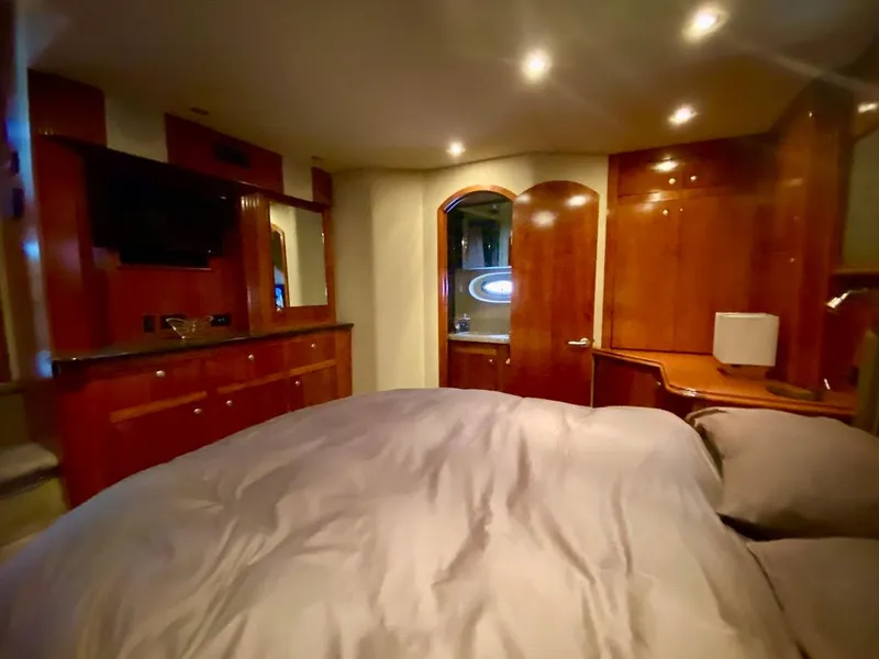 Slide: The Image of Luxurious 2005 Cruisers Yachts 405 Express Motoryacht bedroom with wood cabinetry and ambient lighting. - 38