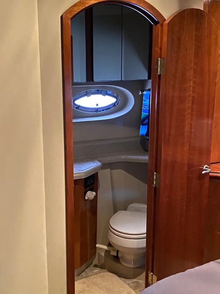 Slide: The Image of 2005 Cruisers Yachts 405 Express Motoryacht bathroom with wooden door and porthole window. - 39