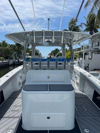 Slide: The Image of 2020 Freeman 34VH boat, sleek design, docked near palm trees under a clear blue sky. - 13