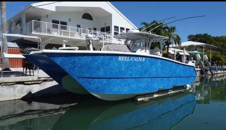 Slide: The Image of Blue Freeman 34VH boat docked by a waterfront house, 2020 model. - 2