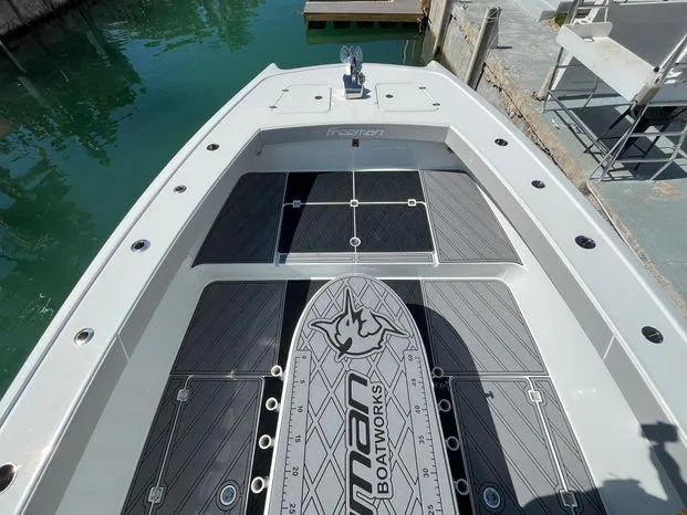 Slide: The Image of 2020 Freeman 34VH boat deck with custom flooring, docked by clear water. - 21