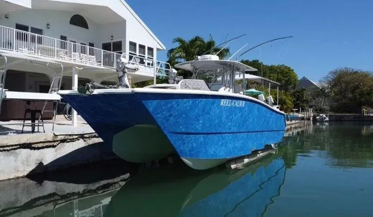 Slide: The Image of 2020 Freeman 34VH boat docked by waterfront home, clear blue sky. - 5