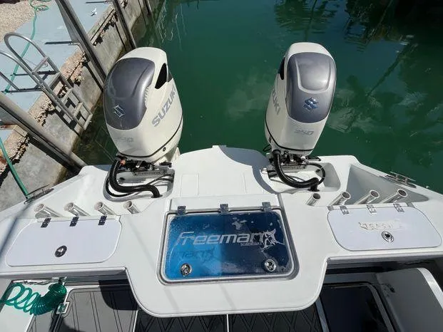Slide: The Image of Freeman 34VH 2020 boat with twin Suzuki outboard motors docked by the water. - 9