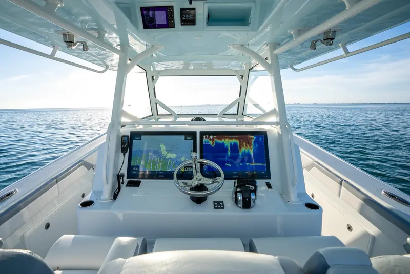 Slide: The Image of 2021 Yellowfin 42 boat dashboard with dual navigation screens on open water. - 26