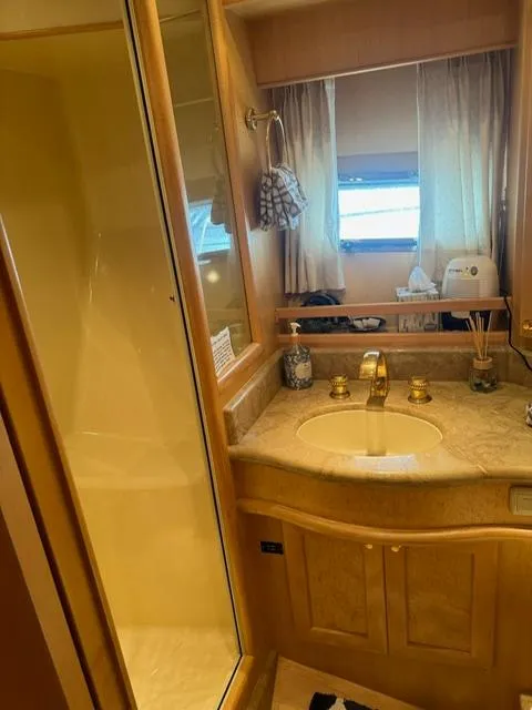 Slide: The Image of Luxurious bathroom in 2000 McKinna 57 Pilothouse yacht with gold fixtures and marble countertop. - 17