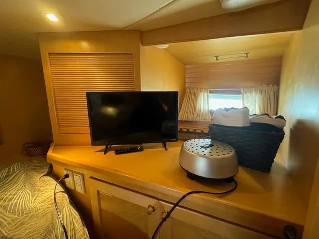 Slide: The Image of 2000 McKinna 57 Pilothouse interior with TV, basket, and porthole window. - 19
