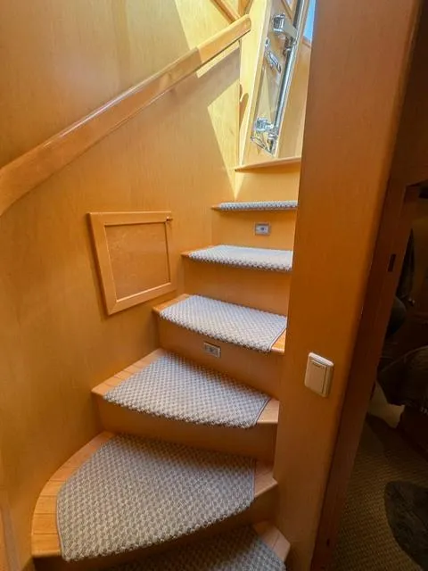 Slide: The Image of Staircase in 2000 McKinna 57 Pilothouse yacht with carpeted steps and wooden handrail. - 20