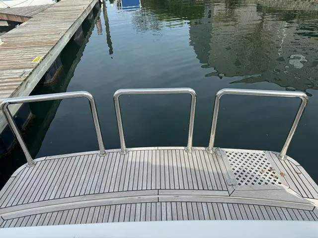 Slide: The Image of McKinna 57 Pilothouse 2000 yacht stern with wooden deck and metal railings. - 23