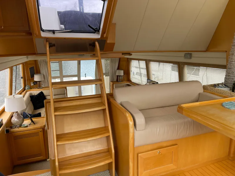 Slide: The Image of Luxurious interior of 2000 McKinna 57 Pilothouse yacht with wooden finishes and seating area. - 4