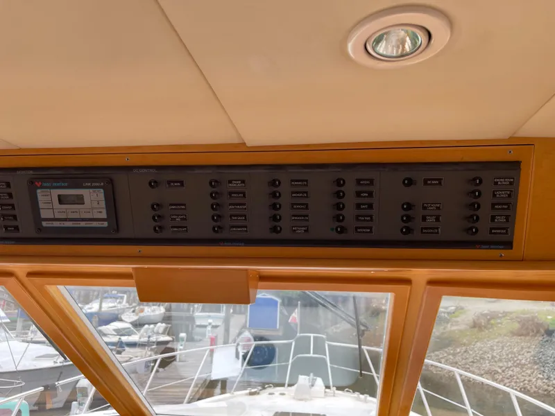 Slide: The Image of Control panel of a 2000 McKinna 57 Pilothouse yacht, featuring various switches and a display. - 41