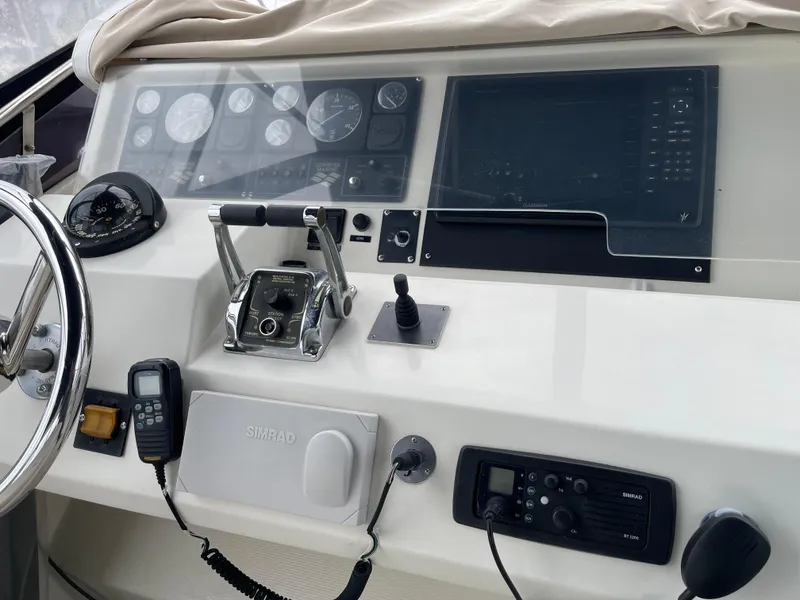 Slide: The Image of Control panel of a 2000 McKinna 57 Pilothouse yacht with steering wheel and navigation instruments. - 42