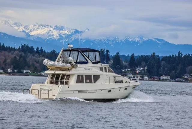 Slide: The Image of McKinna 57 Pilothouse yacht cruising on a scenic lake with mountains in the background. - 5