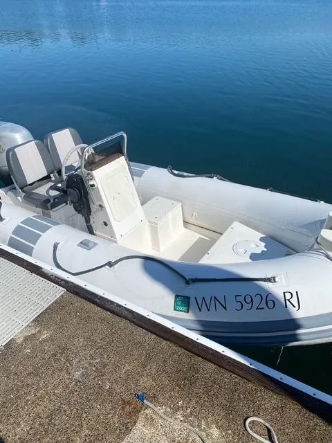Slide: The Image of White inflatable boat docked on calm water, registration WN 5926 RJ visible. - 6