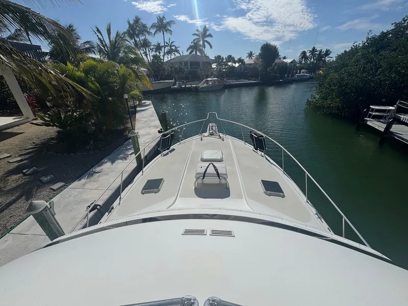 Slide: The Image of 1989 Bertram 50 Convertible yacht docked in a tropical canal setting. - 10