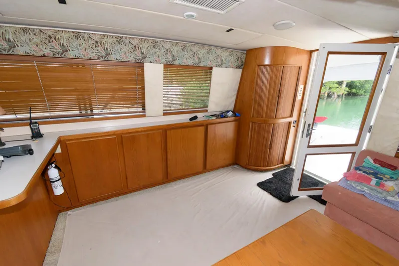 Slide: The Image of Interior of 1989 Bertram 50 Convertible yacht with wooden cabinetry and open door to deck. - 17