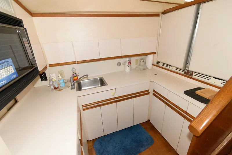 Slide: The Image of 1989 Bertram 50 Convertible yacht kitchen with white cabinets and stainless steel sink. - 18