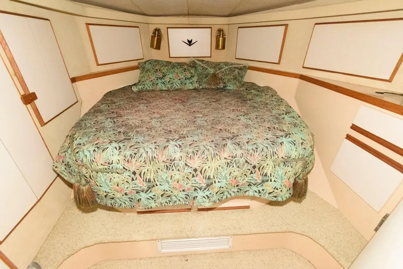 Slide: The Image of 1989 Bertram 50 Convertible cabin with floral bedding and wood accents. - 19