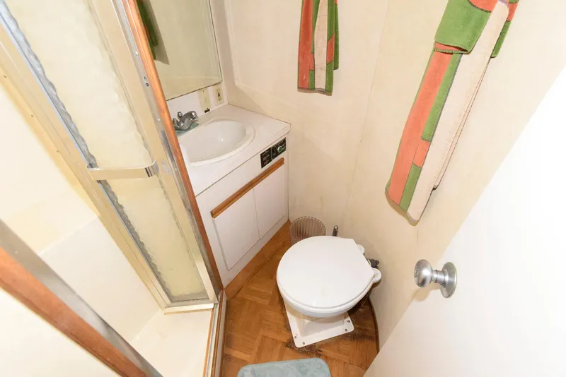 Slide: The Image of Compact bathroom in a 1989 Bertram 50 Convertible yacht with shower, sink, and toilet. - 20