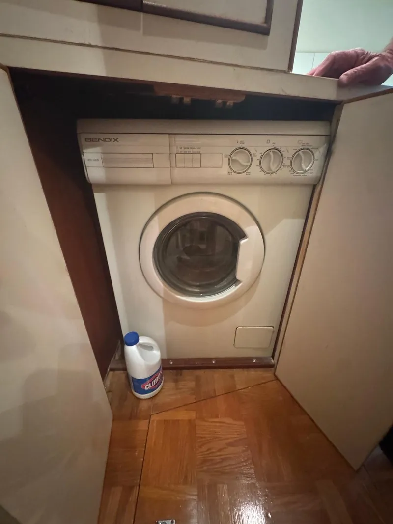 Slide: The Image of Compact washing machine in a wooden cabinet on a 1989 Bertram 50 Convertible yacht. - 23