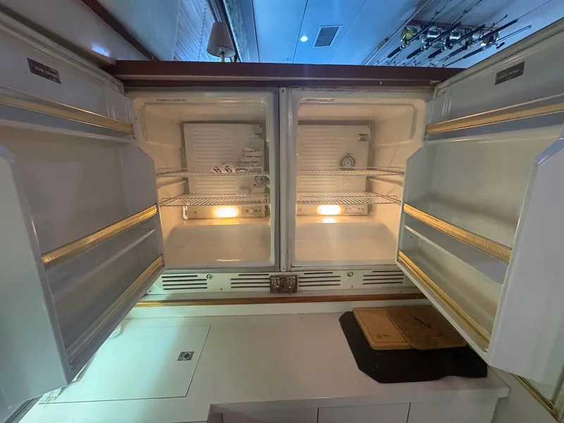 Slide: The Image of 1989 Bertram 50 Convertible yacht kitchen with open double-door refrigerator. - 25