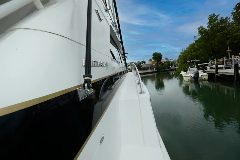 Slide: The Image of 1989 Bertram 50 Convertible yacht docked in a serene marina setting. - 5