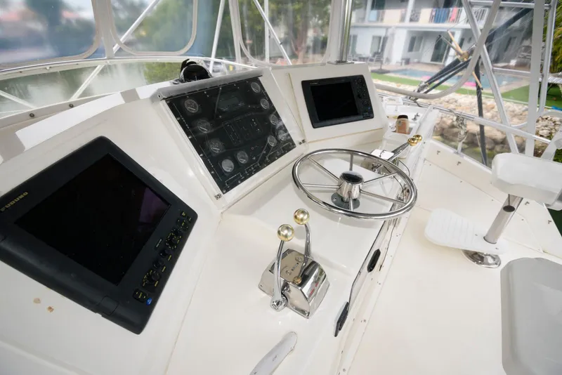 Slide: The Image of 1989 Bertram 50 Convertible helm with steering wheel and navigation screens. - 8