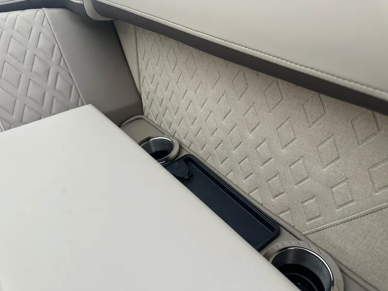 Slide: The Image of Luxurious interior of 2025 Bennington 22MFB with diamond-patterned upholstery and cup holders. - 14