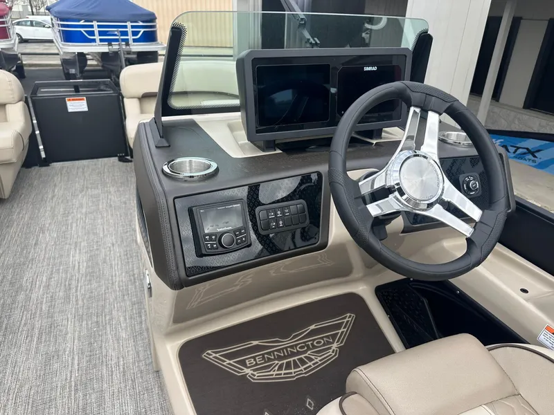 Slide: The Image of 2025 Bennington 22MFB boat dashboard with steering wheel and navigation display. - 21