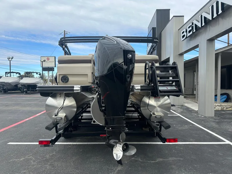 Slide: The Image of 2025 Bennington 22MFB pontoon boat with powerful outboard motor, displayed at dealership. - 4