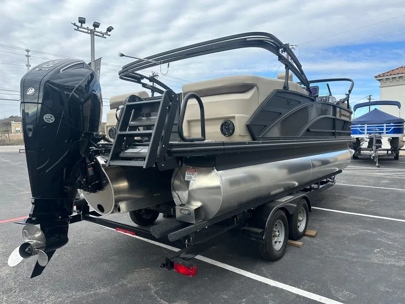 Slide: The Image of 2025 Bennington 22MFB pontoon boat on trailer, featuring a powerful outboard motor. - 7