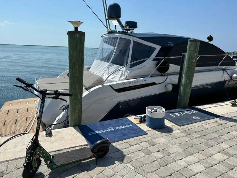 Slide: The Image of 2021 Azimut Atlantis 45 yacht docked by the sea with a scooter nearby. - 14