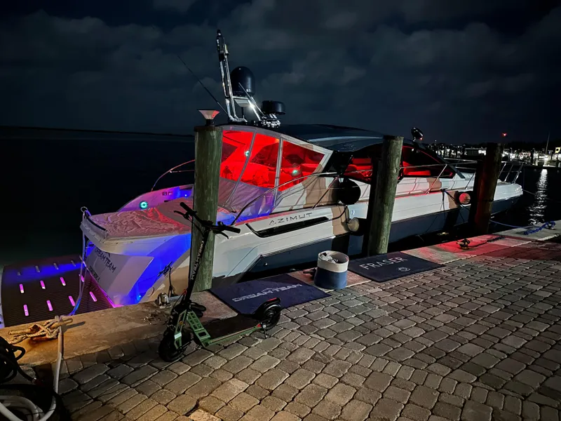 Slide: The Image of Azimut Atlantis 45 yacht docked at night, illuminated with vibrant red and blue lights. - 18