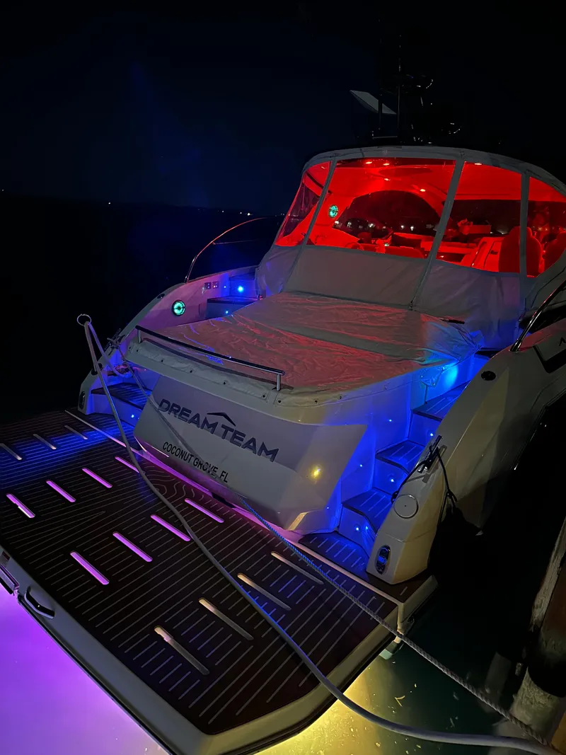 Slide: The Image of Azimut Atlantis 45 yacht, 2021 model, illuminated with vibrant red and blue lights at night. - 36