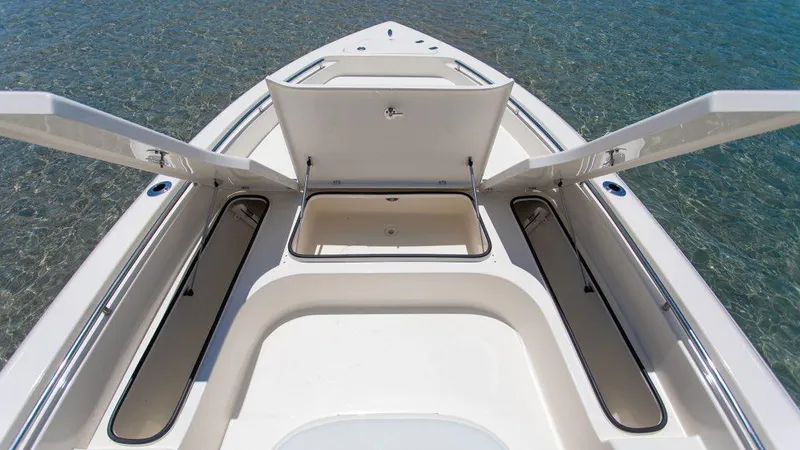 Slide: The Image of 2023 ShearWater 250 XTE boat with open storage compartments on clear water. - 9