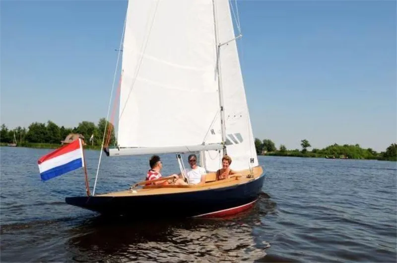 Slide: The Image of Sailing on a Rustler 24 boat, 2025 model, with a Dutch flag on a calm lake. - 10