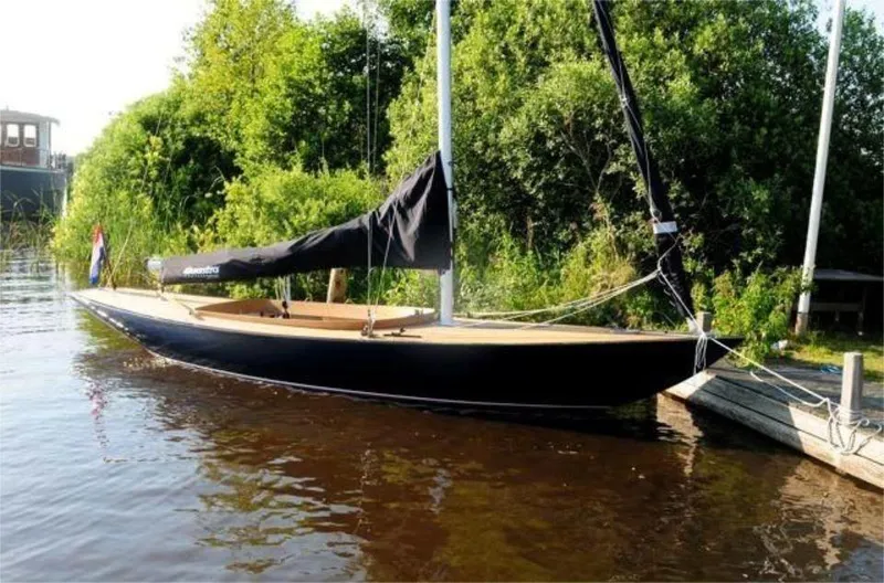 Slide: The Image of 2025 Rustler 24 sailboat docked by lush greenery on a sunny day. - 13