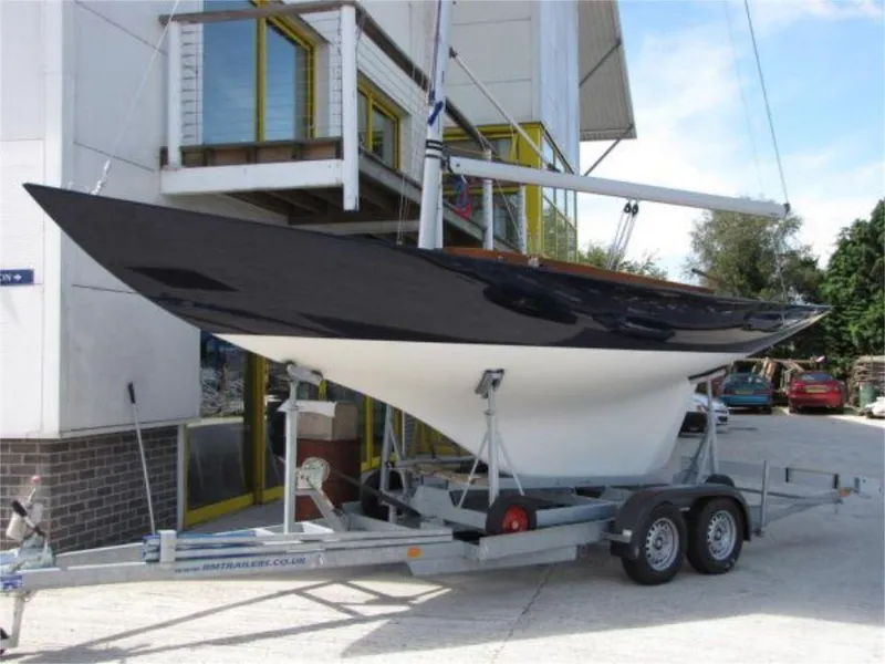 Slide: The Image of 2025 Rustler 24 sailboat on trailer outside building. - 23