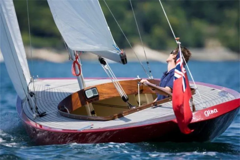 Slide: The Image of Sailing on a Rustler 24 yacht, 2025 model, with a vibrant red hull and flag. - 3
