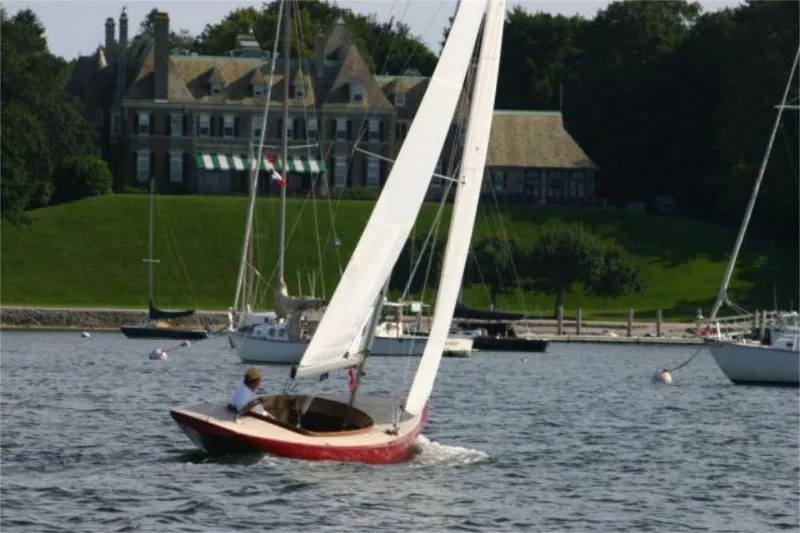 Slide: The Image of Sailboat Rustler 24 (2025) on water near elegant estate, lush greenery in background. - 5