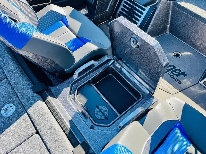 Slide: The Image of 2025 Ranger Z520R Cup-Equipped boat interior with open storage compartment and blue seats. - 36