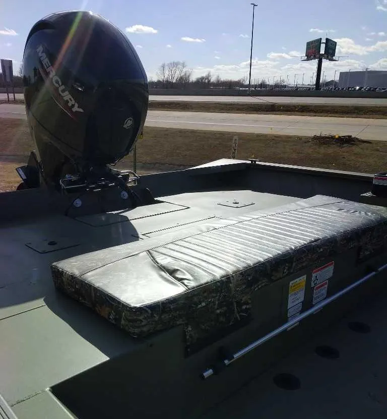 Slide: The Image of 2025 Tracker Grizzly 2072 CC boat with Mercury outboard motor, parked outdoors. - 6