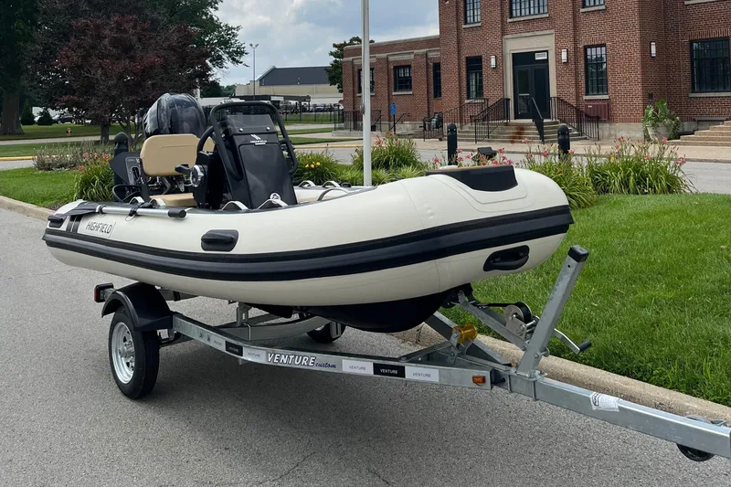 Slide: The Image of 2025 Highfield Classic 360 GT boat on trailer, parked near a brick building. - 9