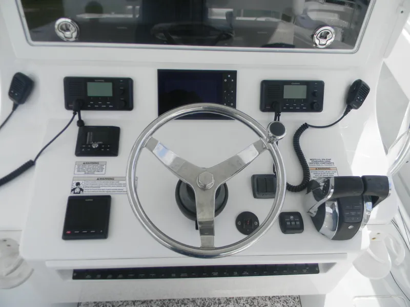 Slide: The Image of Control panel of a 2019 Contender 39 ST boat with steering wheel and navigation equipment. - 11