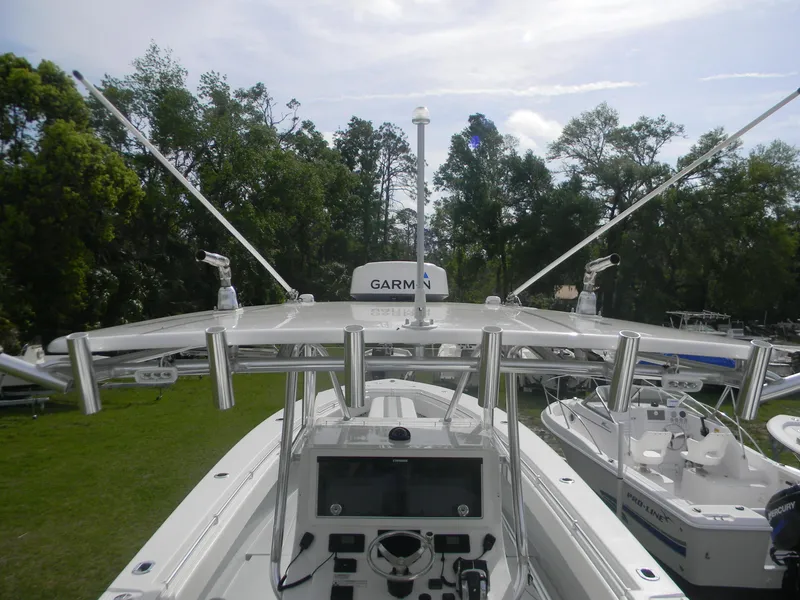 Slide: The Image of 2019 Contender 39 ST boat with advanced navigation equipment and rod holders, surrounded by trees. - 14