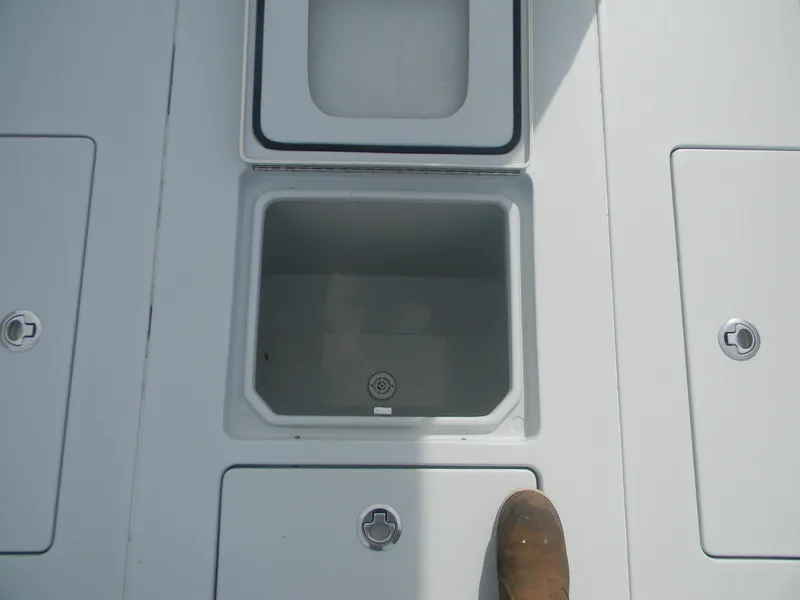 Slide: The Image of 2019 Contender 39 ST boat storage compartments with open hatch and visible foot. - 15